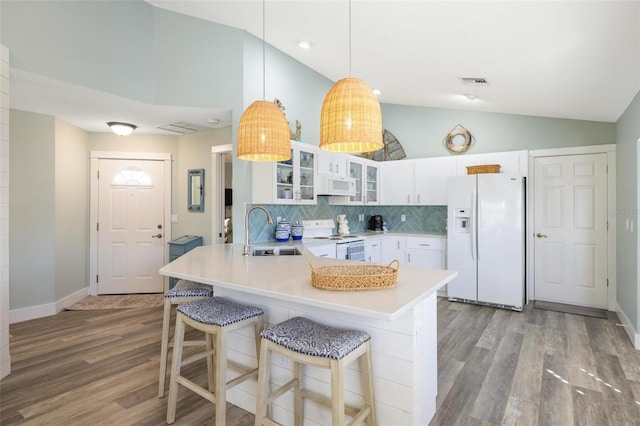 kitchen featuring white cabinets, pendant lighting, light hardwood / wood-style floors, sink, and white appliances