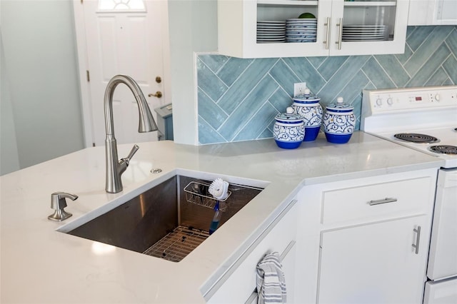 kitchen with sink, white cabinets, decorative backsplash, and white electric stove