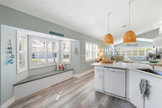 kitchen with white cabinets, wood-type flooring, dishwasher, decorative light fixtures, and sink