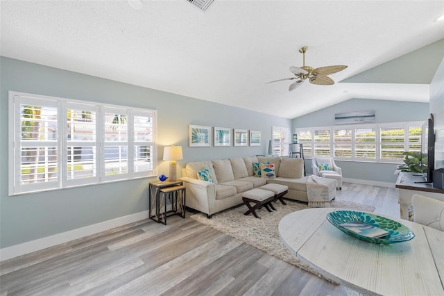 living room featuring vaulted ceiling, light wood-type flooring, and ceiling fan