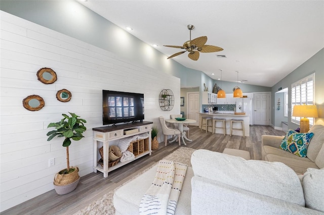 living room with ceiling fan, dark wood-type flooring, and vaulted ceiling