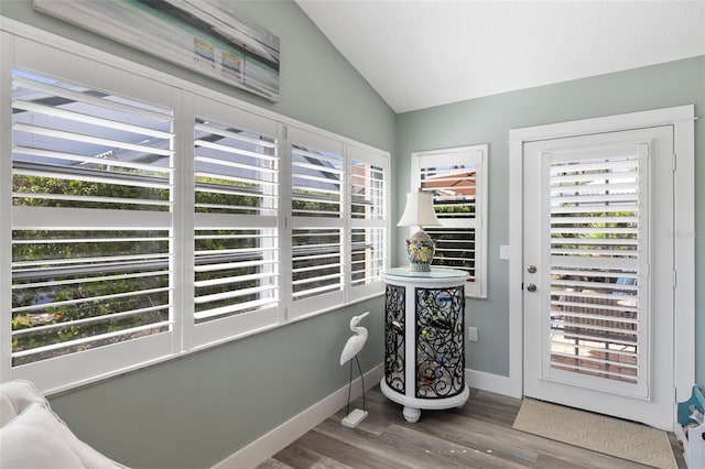 doorway featuring vaulted ceiling and hardwood / wood-style flooring