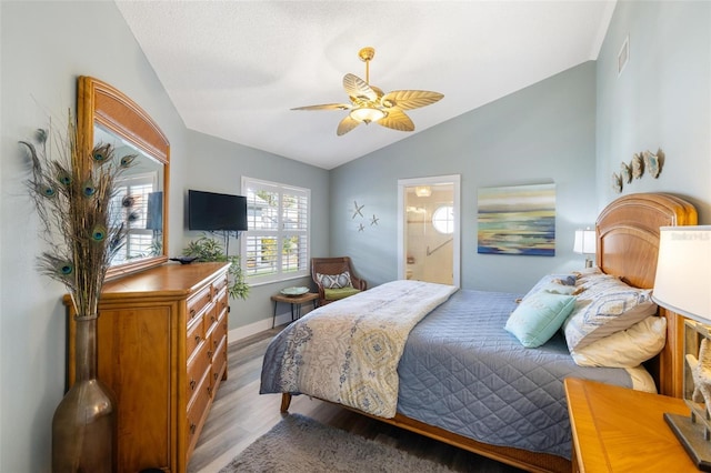 bedroom with ensuite bathroom, lofted ceiling, light hardwood / wood-style floors, and ceiling fan