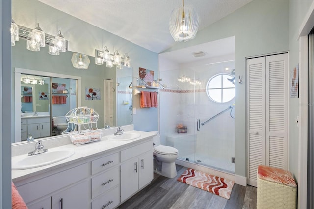 bathroom featuring hardwood / wood-style floors, a textured ceiling, toilet, a shower with shower door, and vanity