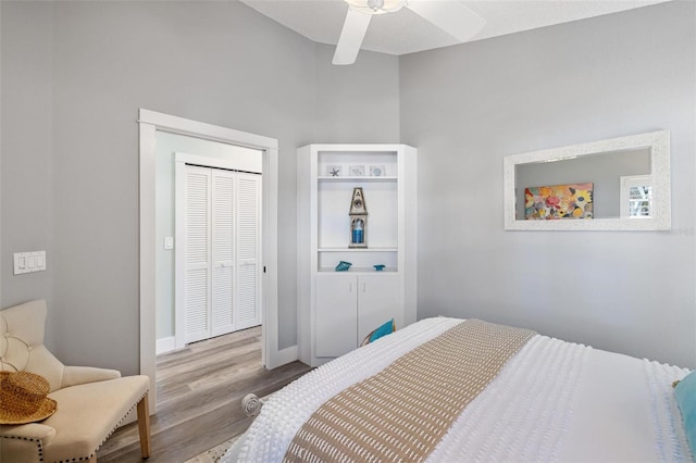 bedroom with light hardwood / wood-style floors, a closet, a textured ceiling, and ceiling fan