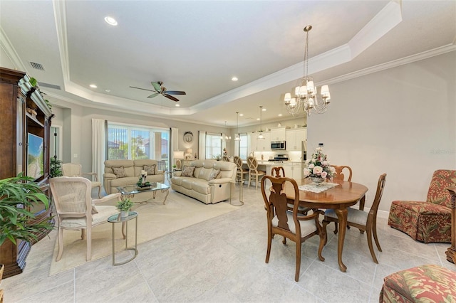 dining area with ornamental molding, a raised ceiling, and ceiling fan with notable chandelier