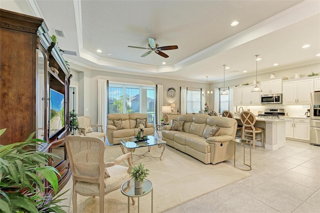 living room with light tile patterned floors, crown molding, a raised ceiling, and ceiling fan