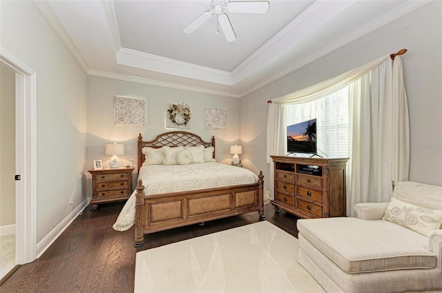 bedroom with a raised ceiling, dark hardwood / wood-style flooring, crown molding, and ceiling fan