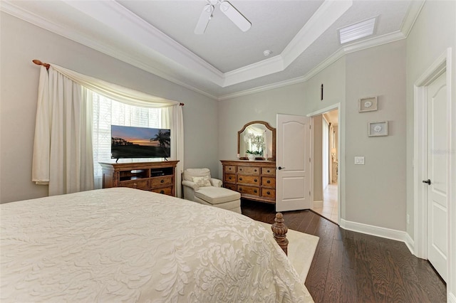 bedroom with dark wood-type flooring, ornamental molding, a raised ceiling, and ceiling fan