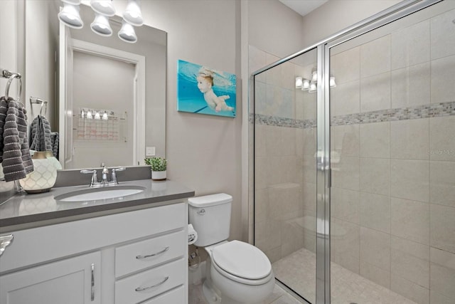 bathroom featuring vanity, toilet, and an enclosed shower