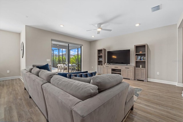 living room featuring light hardwood / wood-style floors and ceiling fan