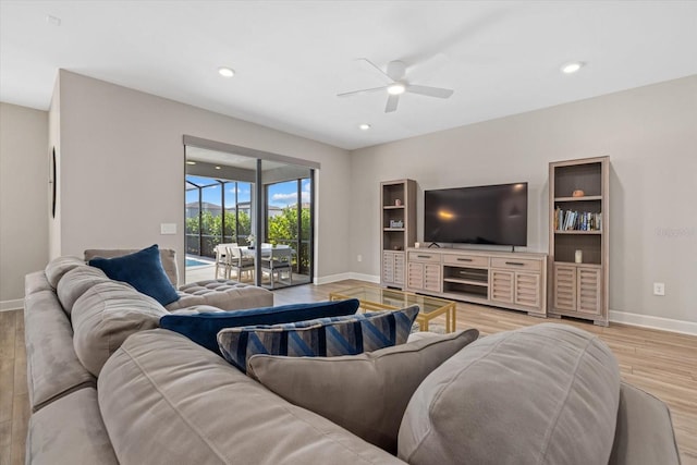 living room with light hardwood / wood-style flooring and ceiling fan