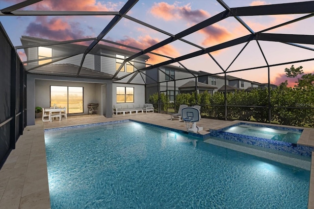 pool at dusk featuring an in ground hot tub, a patio, and a lanai