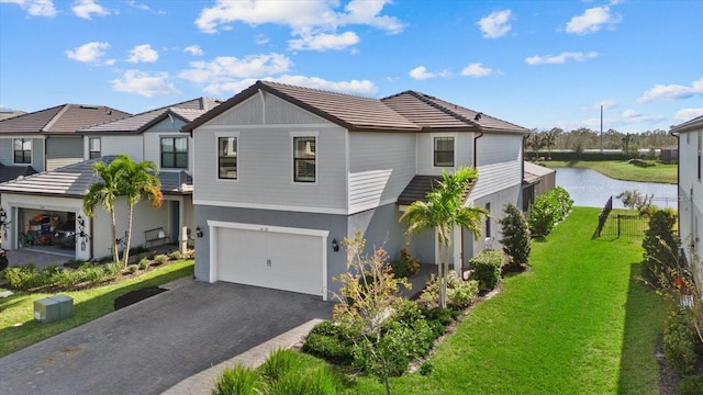 view of front of house featuring a water view, a front lawn, and a garage