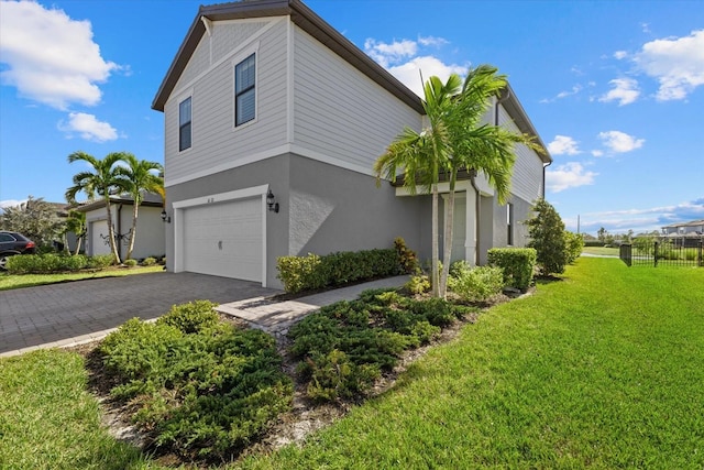 view of home's exterior with a garage and a lawn