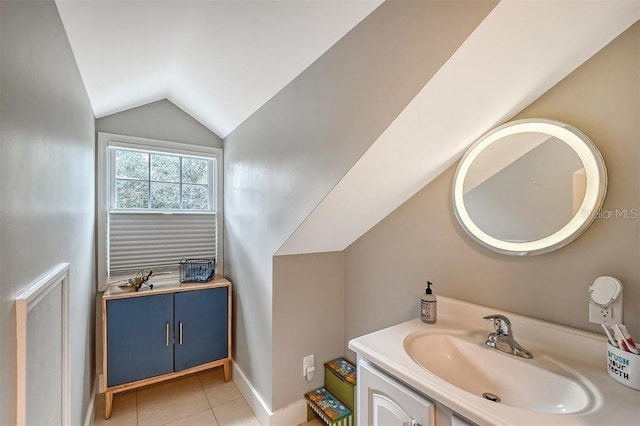 bathroom featuring baseboards, lofted ceiling, tile patterned flooring, and vanity