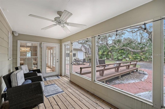 sunroom with a wooden deck, hardwood / wood-style floors, and ceiling fan