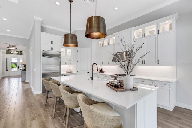 kitchen featuring white cabinetry, a kitchen island with sink, and sink