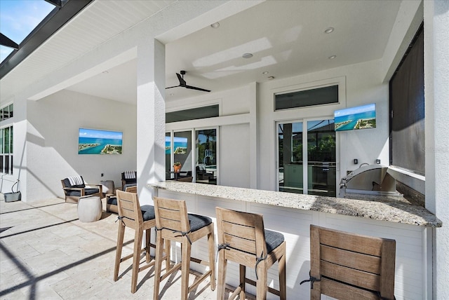 kitchen featuring light stone counters and ceiling fan