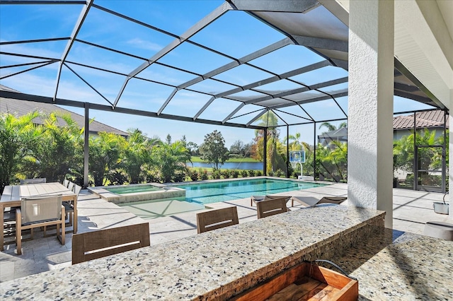 view of swimming pool with a water view, a patio, a lanai, and an in ground hot tub