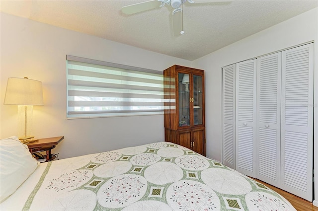 bedroom with a closet, hardwood / wood-style floors, a textured ceiling, and ceiling fan