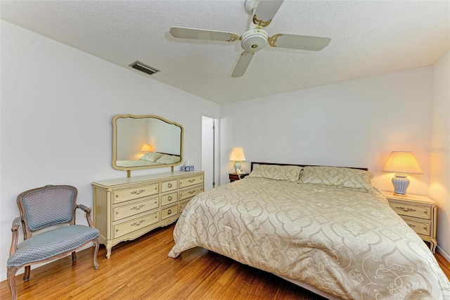 bedroom featuring ceiling fan, a textured ceiling, and light hardwood / wood-style flooring