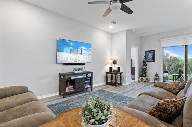 living room with wood-type flooring and ceiling fan