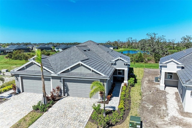 single story home with a garage and a water view