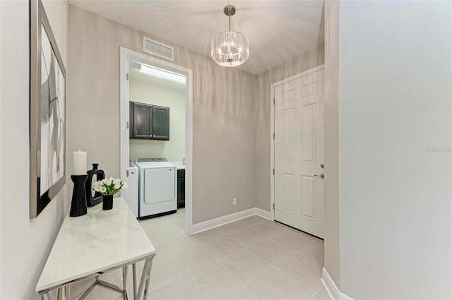 interior space featuring a chandelier, washer and clothes dryer, and light tile patterned flooring