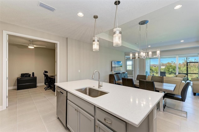 kitchen with dishwasher, a kitchen island with sink, hanging light fixtures, sink, and gray cabinets