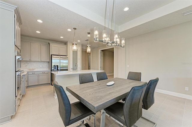 tiled dining room featuring a notable chandelier and a textured ceiling