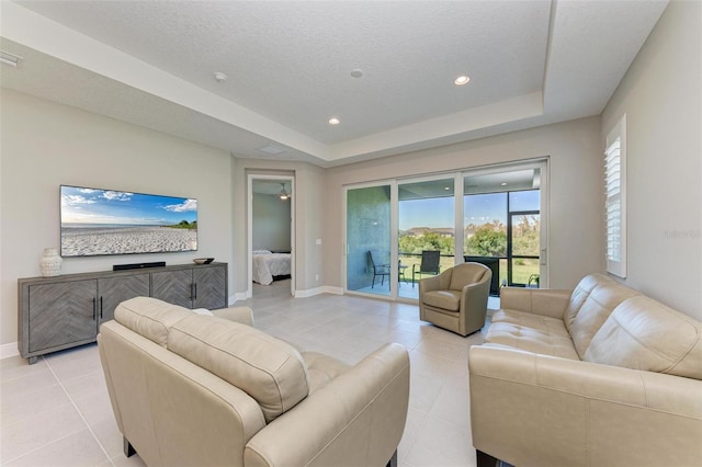 tiled living room featuring a textured ceiling and a tray ceiling