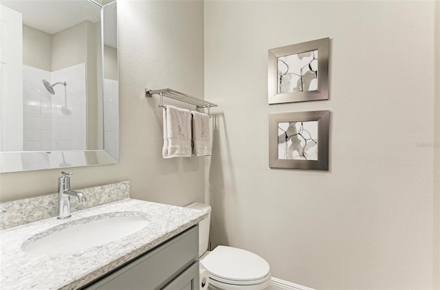 bathroom featuring vanity, a shower, and toilet