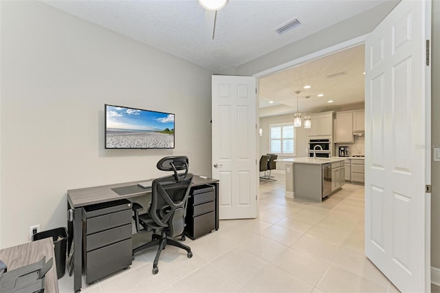 tiled office space with a textured ceiling