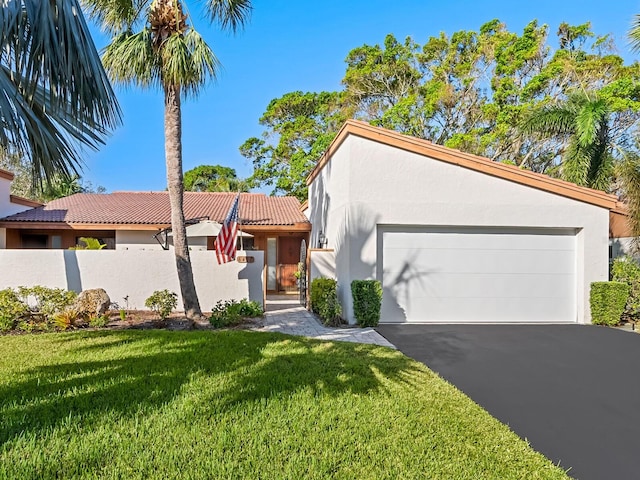 6417 Meadowlark Ln Unit 6417, Bradenton, FL 34210 - view of front facade featuring a garage, a front lawn, fence, stucco siding, and a tiled roof