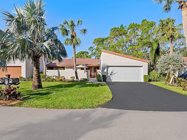 6417 Meadowlark Ln Unit 6417, Bradenton, FL 34210 - view of front of property with a tile roof, a front lawn, a garage, aphalt driveway, and stucco siding