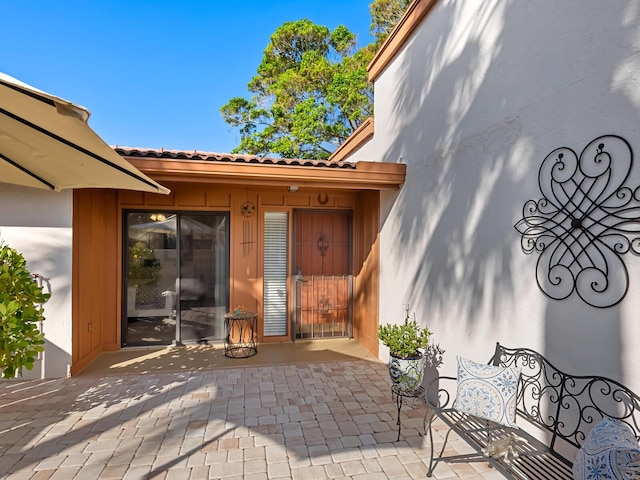 view of exterior entry featuring a patio area