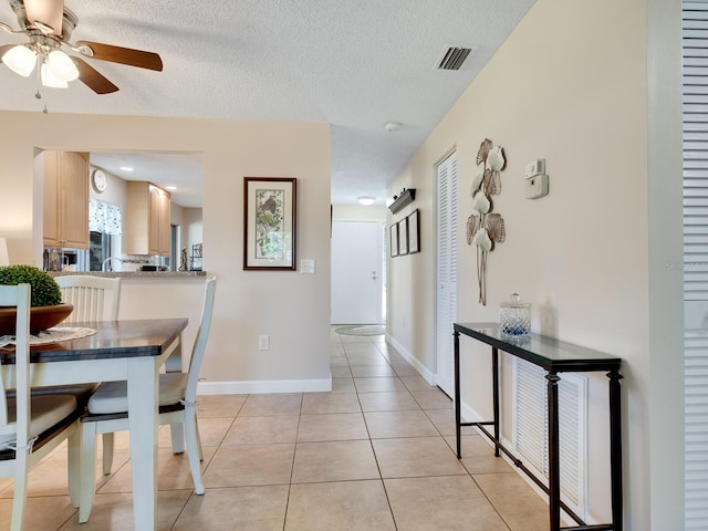 dining room featuring ceiling fan, a textured ceiling, and light tile patterned floors