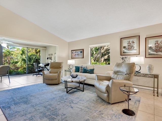 living room with lofted ceiling, ceiling fan, and light tile patterned floors