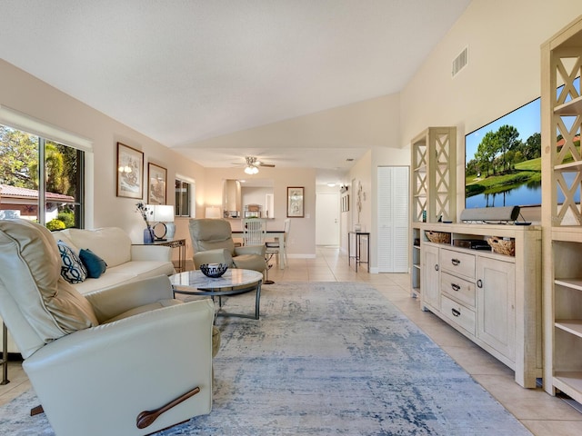 living room with ceiling fan, light tile patterned flooring, and vaulted ceiling