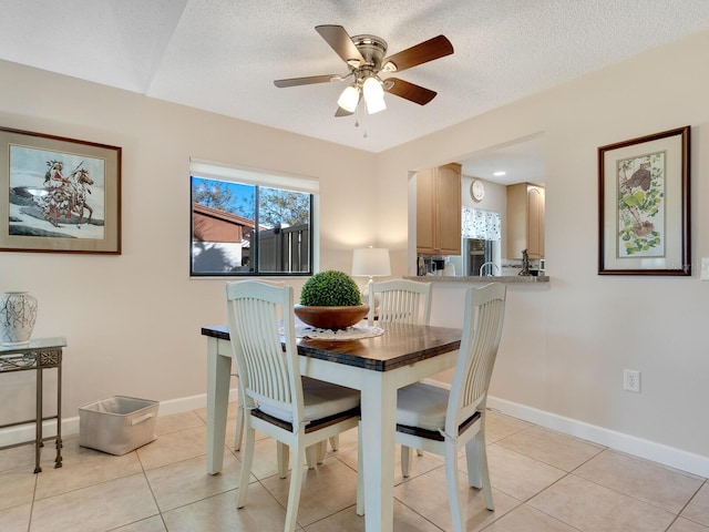 dining space featuring ceiling fan, a textured ceiling, and light tile patterned floors