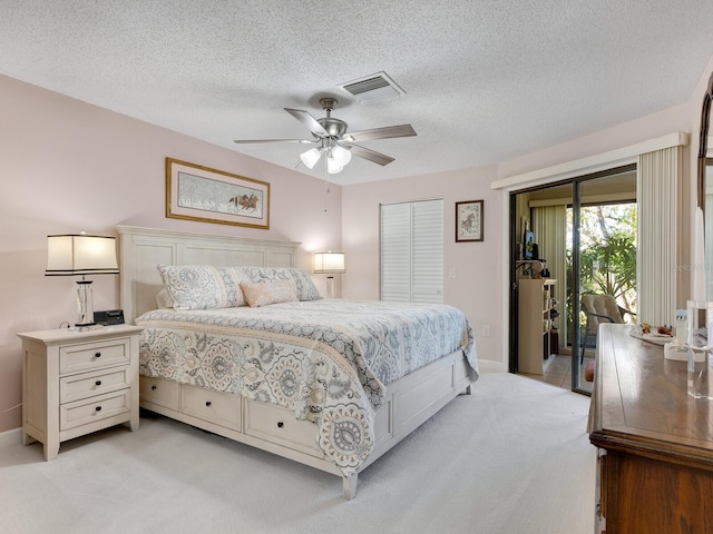 carpeted bedroom with a closet, a textured ceiling, access to exterior, and ceiling fan