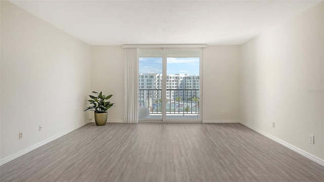 spare room with wood-type flooring and floor to ceiling windows