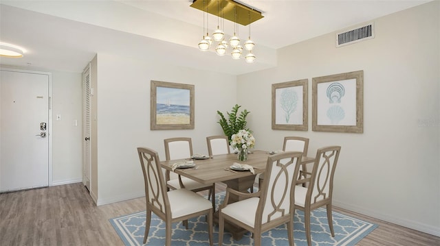 dining area featuring light hardwood / wood-style flooring and a chandelier