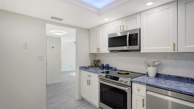 kitchen featuring white cabinetry, ornamental molding, and appliances with stainless steel finishes