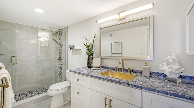 bathroom with a shower with door, vanity, and toilet