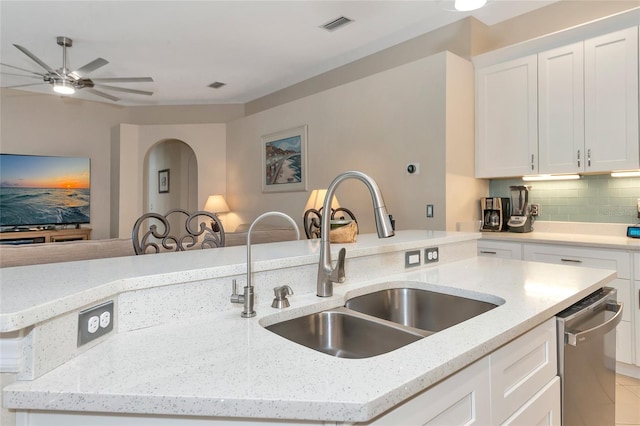 kitchen with sink, dishwasher, white cabinetry, and light stone counters