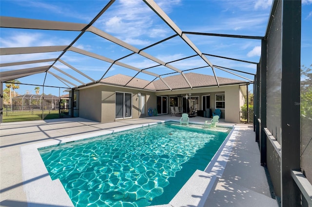 view of swimming pool featuring a patio and glass enclosure