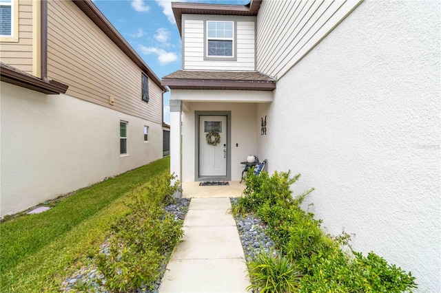 property entrance featuring a lawn