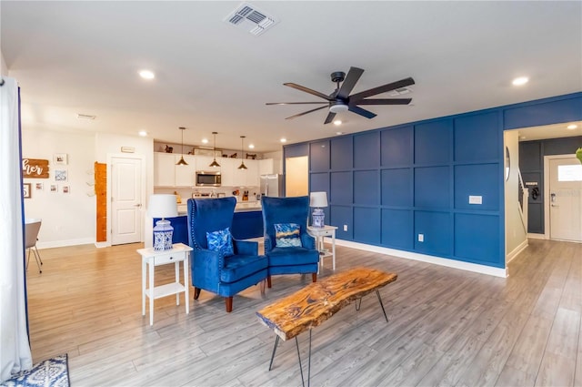 living room with light wood-type flooring and ceiling fan